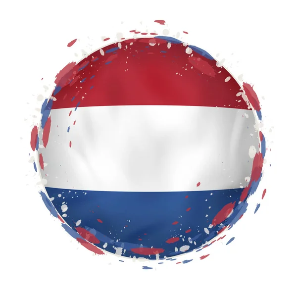 Runde Grunge Flagge der Niederlande mit Spritzern in Flaggenfarbe. — Stockvektor