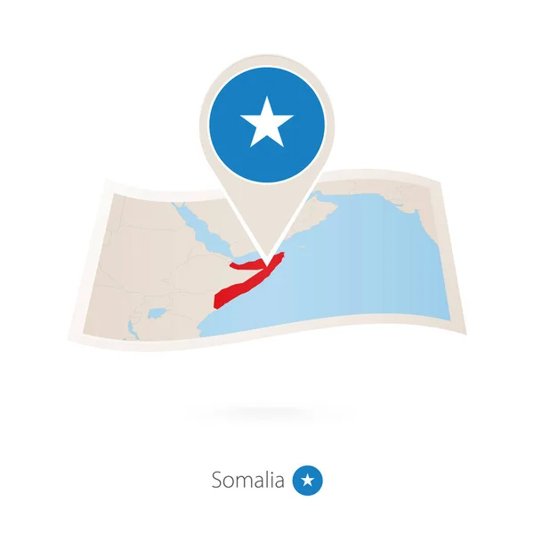 Skládané papíru mapu Somálsko s vlajku pin Somálsko. — Stockový vektor