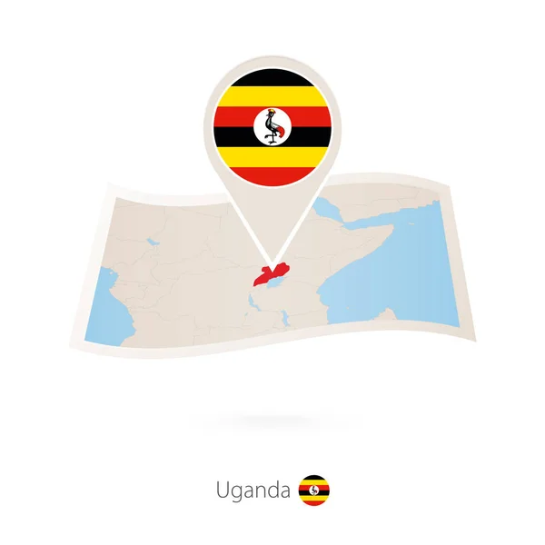 Składany papier mapę Ugandy z pin flaga Ugandy. — Wektor stockowy