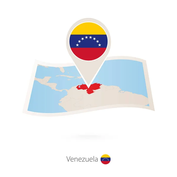 Gevouwen papieren kaart van Venezuela met vlag pin van Venezuela. — Stockvector