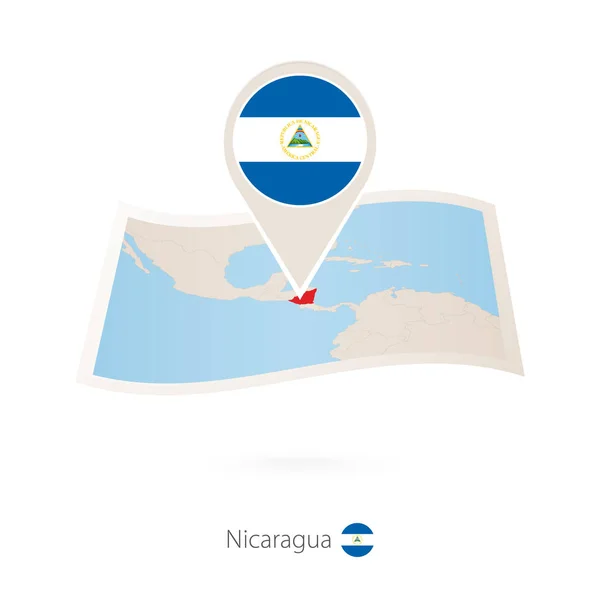 Folded paper map of Nicaragua with flag pin of Nicaragua. — Stock Vector