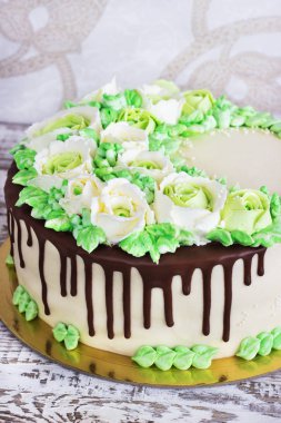 Güllü krem Beyaz ahşap zemin üzerinde yapılan kutlama pastası