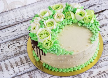 Güllü krem Beyaz ahşap zemin üzerinde yapılan kutlama pastası