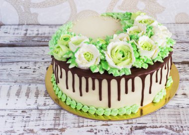 Güllü krem Beyaz ahşap zemin üzerinde yapılan kutlama pastası