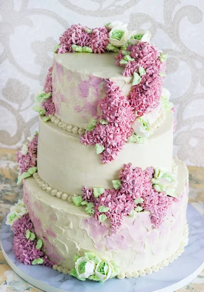 Свадебный праздничный торт со сливочными цветами сирень на белом фоне — стоковое фото