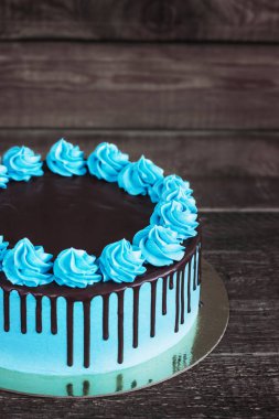 Doğum günü pastası ile koyu ahşap arka plan üzerinde krem çikolata damlar