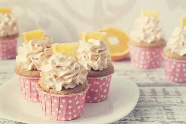 Vanilkové cupcakes s cap krém na bílý dřevěný stůl — Stock fotografie