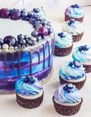 Çilek ve çikolata ve krema ile cupcakes ile parlak Festival mavi pasta