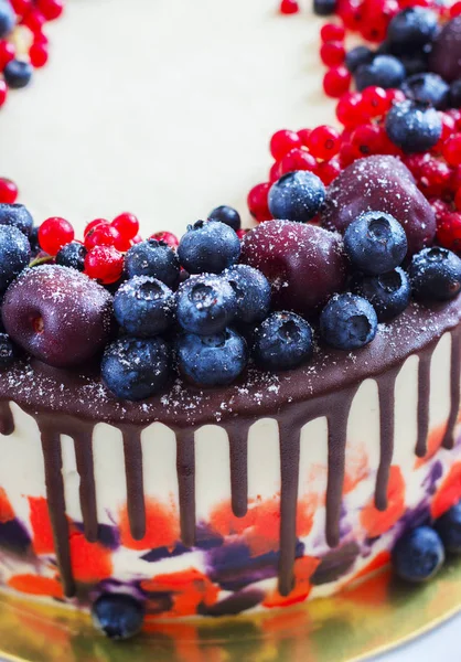 Bright festive cake with berries and chocolate on a white wooden background — Stock Photo, Image