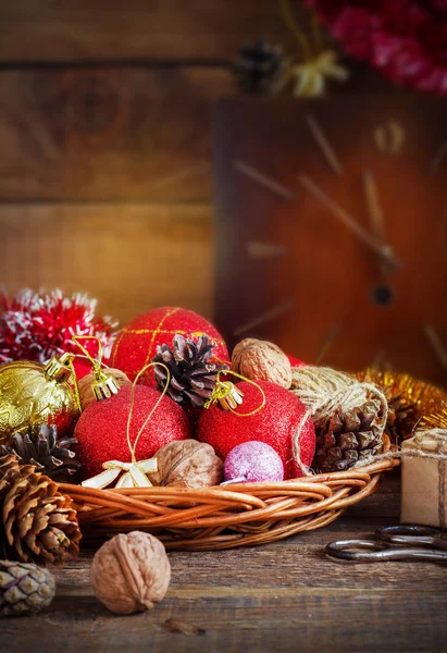 Composição de Natal com Presentes. Cesta, bolas vermelhas, cones de pinho, flocos de neve na mesa de madeira. Estilo vintage — Fotografia de Stock