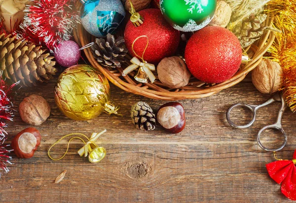 Composition de Noël avec cadeaux. Panier, boules rouges, cônes de pin, flocons de neige sur table en bois. Style vintage — Photo