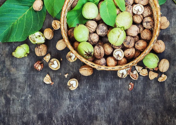 Whole Walnuts and Cleared in the basket Black Wooden Background Top view Healthy concept — Stock Photo, Image