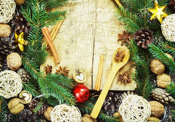 Vieja tabla de cortar con atributos navideños sobre un fondo de cocina de madera —  Fotos de Stock
