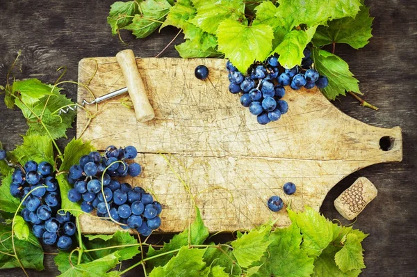 Uvas y cartón viejo sobre fondo de madera — Foto de Stock