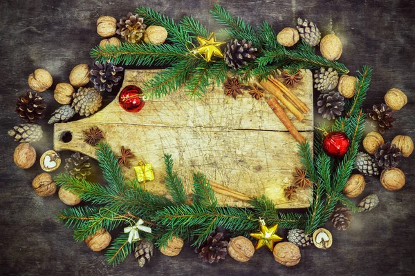 Oude snijplank met Kerstmis kenmerken op de achtergrond van een houten keuken — Stockfoto