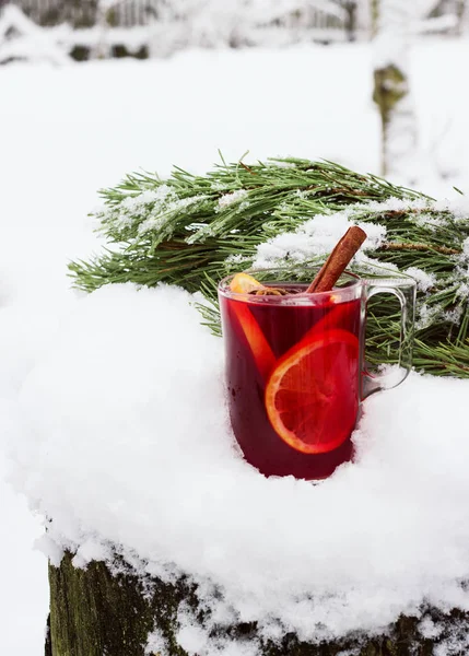 Glühwein auf der Straße im Schnee mit einem Tannenzweig — Stockfoto