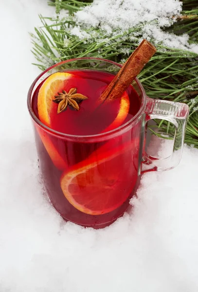 Mulled wine on the street in the snow with a branch of pine — Stock Photo, Image