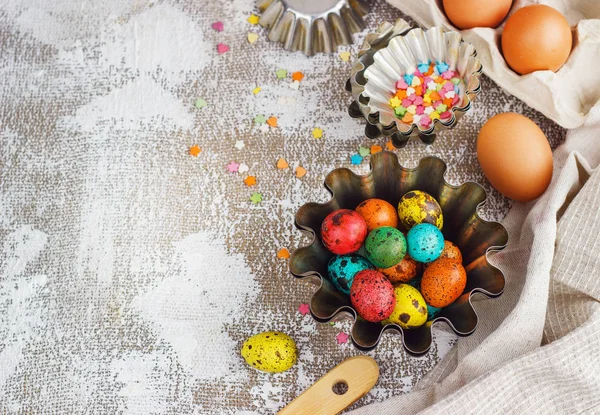 Ovos de páscoa coloridos e moldes de cozimento em um fundo de lona leve, lugar para texto — Fotografia de Stock