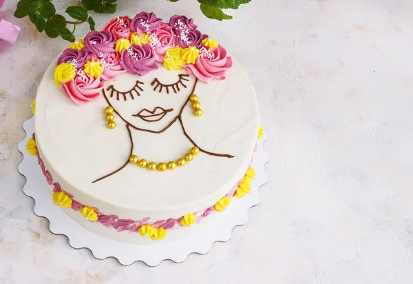 Pastel festivo con flores de crema y una cara de niña sobre un fondo claro —  Fotos de Stock