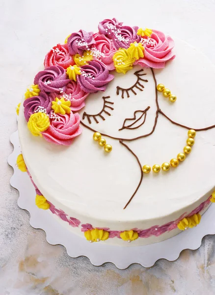 Pastel festivo con flores de crema y una cara de niña sobre un fondo claro —  Fotos de Stock