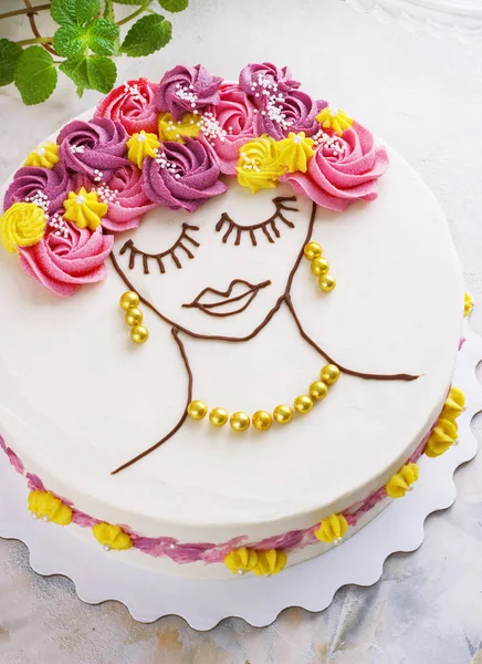 Pastel festivo con flores de crema y una cara de niña sobre un fondo claro —  Fotos de Stock