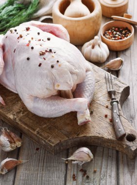 Baharatlı ahşap bir arka planda tavuk leşi, mutfakta yemek pişirmek, kırsal tarzda.