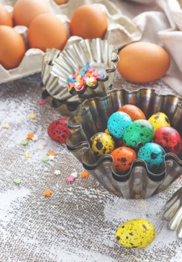 Paskalya yumurtaları ve Pişirme kalıpları ışık tuval arka plan üzerinde renkli, metin için yer