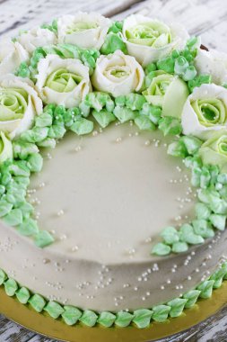 Güllü krem Beyaz ahşap zemin üzerinde yapılan kutlama pastası