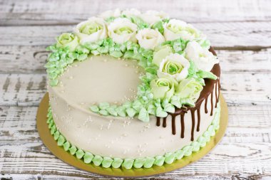 Güllü krem Beyaz ahşap zemin üzerinde yapılan kutlama pastası