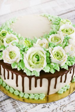 Güllü krem Beyaz ahşap zemin üzerinde yapılan kutlama pastası