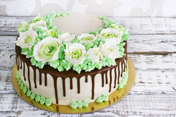 Güllü krem Beyaz ahşap zemin üzerinde yapılan kutlama pastası