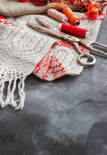 Schaar, klossen met wol en naalden, gestreepte stof. Oude naaien tools op de achtergrond. Vintage achtergrond — Stockfoto