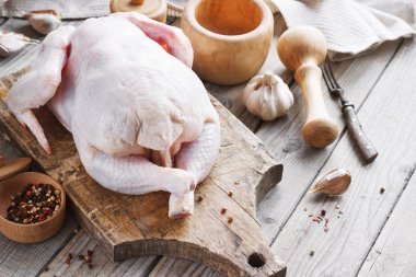 Baharatlı ahşap bir arka planda tavuk leşi, mutfakta yemek pişirmek, kırsal tarzda.