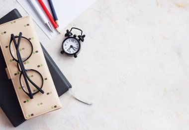 Not defteri günlük, kartvizit, gözlük, saat hafif bir masaya. Kopya alanı, düz Lay ile Üstten Görünüm