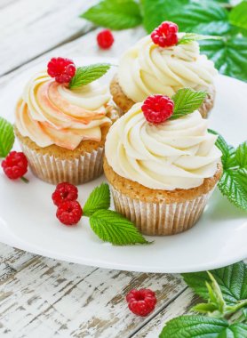 Hassas vanilyalı kek krem ve Beyaz ahşap zemin üzerinde ahududu