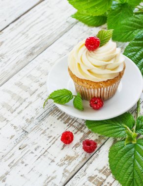 Hassas vanilyalı kek krem ve Beyaz ahşap zemin üzerinde ahududu