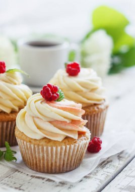 Hassas vanilyalı kek krem ve Beyaz ahşap zemin üzerinde ahududu