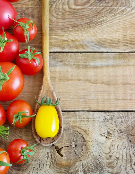 Свіжі червоні та жовті помідори на дерев'яному фоні — стокове фото