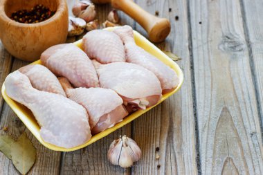 Ahşap arka plan, üstten görünüm üzerinde çiğ tavuk budu ile kase