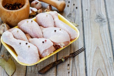 Ahşap arka plan, üstten görünüm üzerinde çiğ tavuk budu ile kase