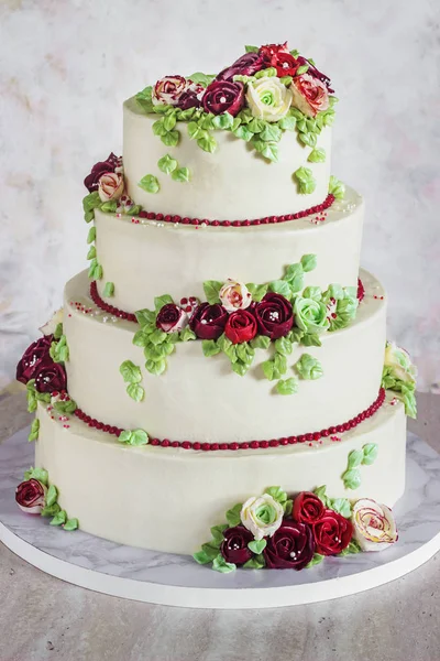 Uroczysty czteropoziomowy biały elegancki tort z kremowymi kwiatami, tort weselny, kremowe kwiaty w technice malezyjskiej — Zdjęcie stockowe
