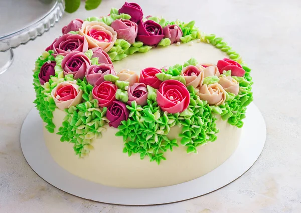 Jasny świąteczny tort z jasnymi kwiatami ze śmietany, tort weselny, dla kobiety. — Zdjęcie stockowe