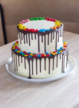 Beyaz Doğum günü pastası ile hafif bir arka plan üzerinde renkli Sprinkles