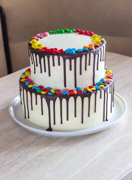 White Birthday cake with colorful Sprinkles over a light background — Stock Photo, Image