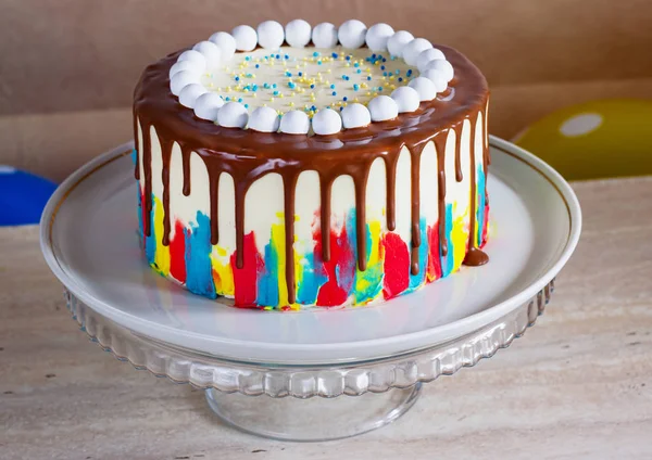 Pastel de cumpleaños brillante con chocolate sobre un fondo claro con globos — Foto de Stock