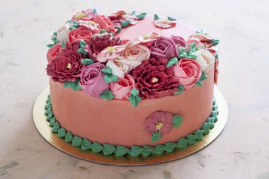 Bright festive cake with bright flowers made of cream, a wedding cake, for a woman.