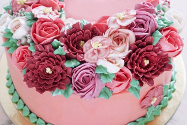 Bright festive cake with bright flowers made of cream, a wedding cake, for a woman.