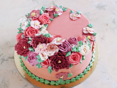 Bright festive cake with bright flowers made of cream, a wedding cake, for a woman.