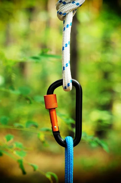 Carabiner with rope on nature background. — Stock Photo, Image