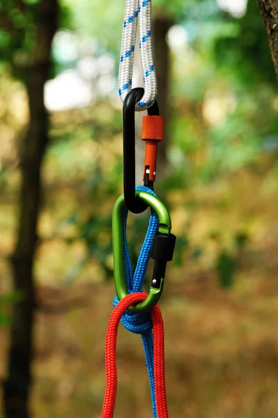 Carabiner with rope on nature background. — Stock Photo, Image